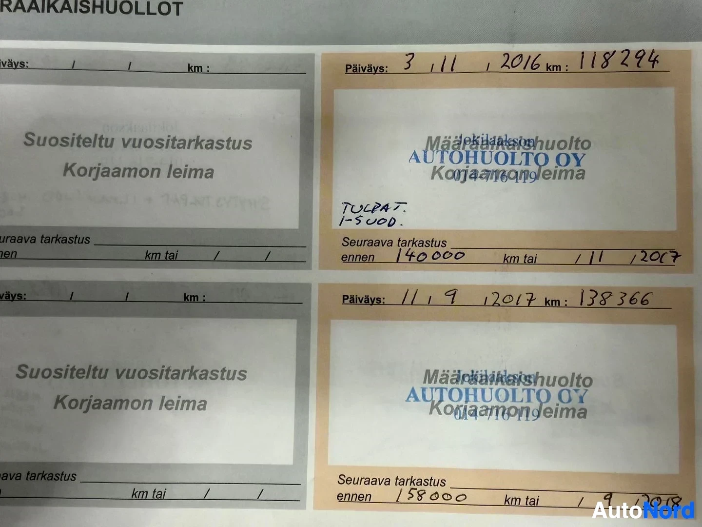 Asiakirja: Huoltokirja-sivuja, joissa näkyvät päivämäärät, kilometrilukemata ja huoltoliikkeiden leimoja