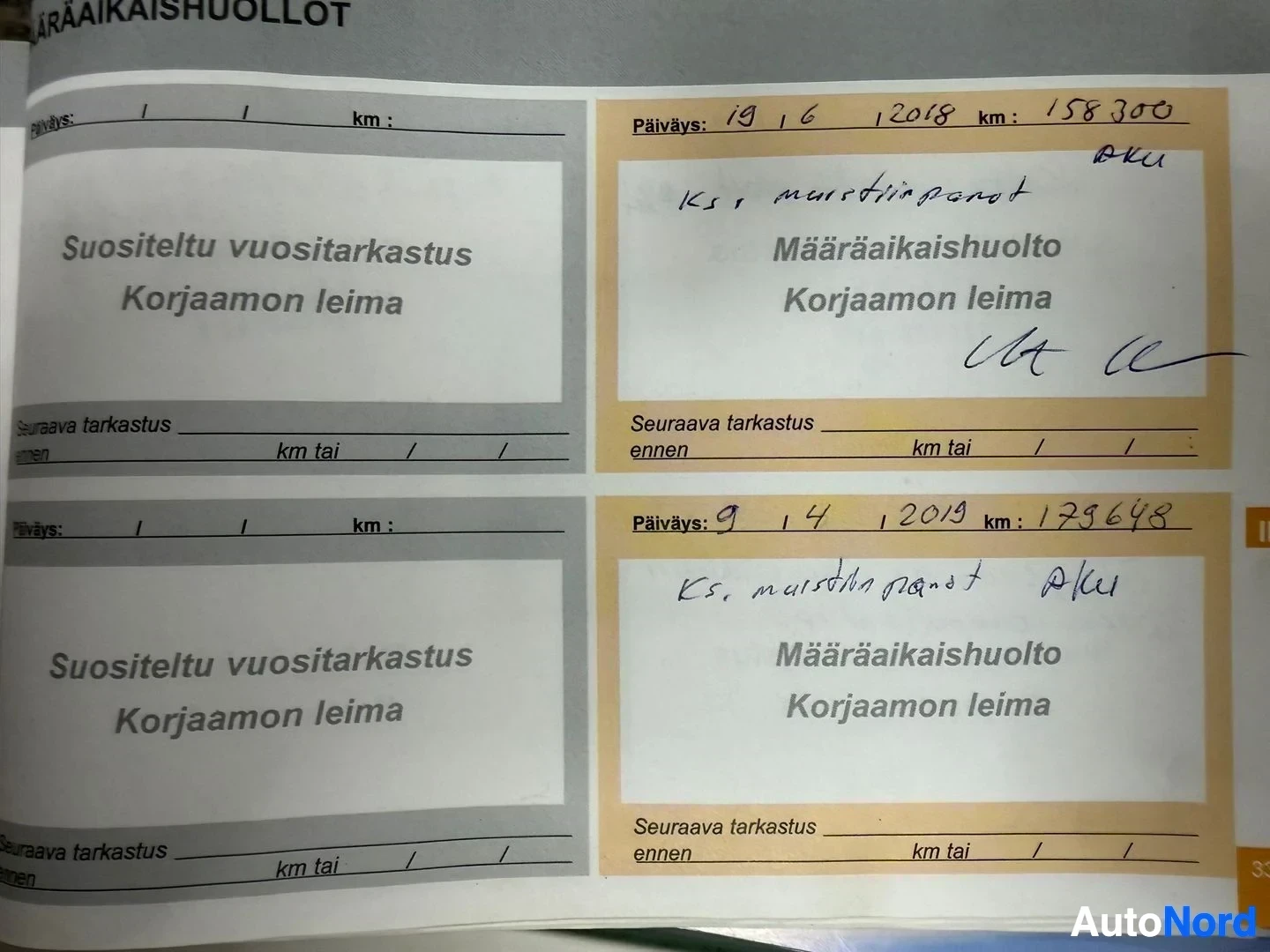 Asiakirja: Huoltokirja-sivuja, joissa näkyvät päivämäärät, kilometrilukemata ja huoltoliikkeiden merkinnät
