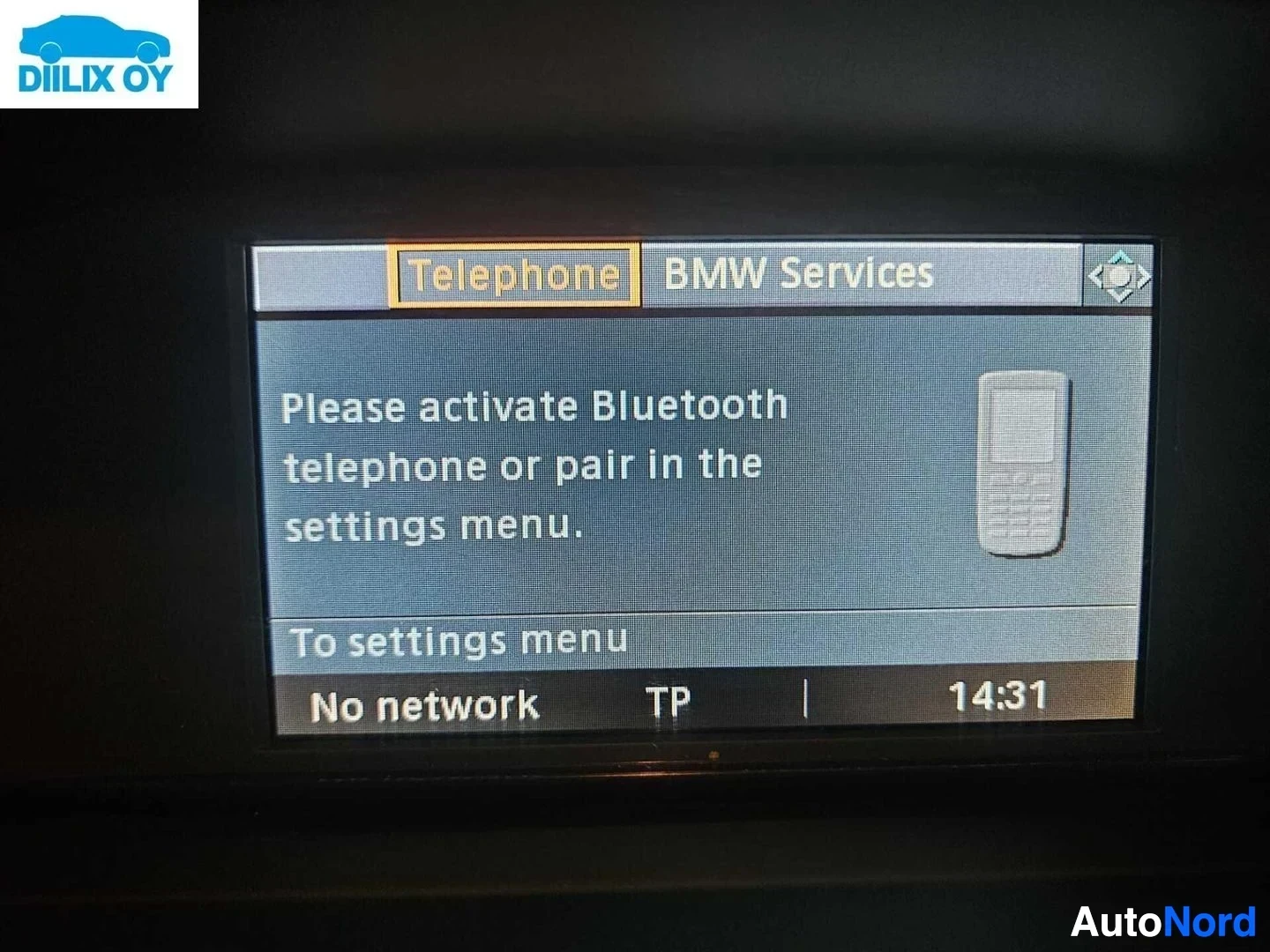 Yksityiskohta: BMW-infotainment-näytön Bluetooth-puhelin-valikko, jonka teksti sanoo 'Aktivoi Bluetooth-puhelin tai parittaa asetuksista'