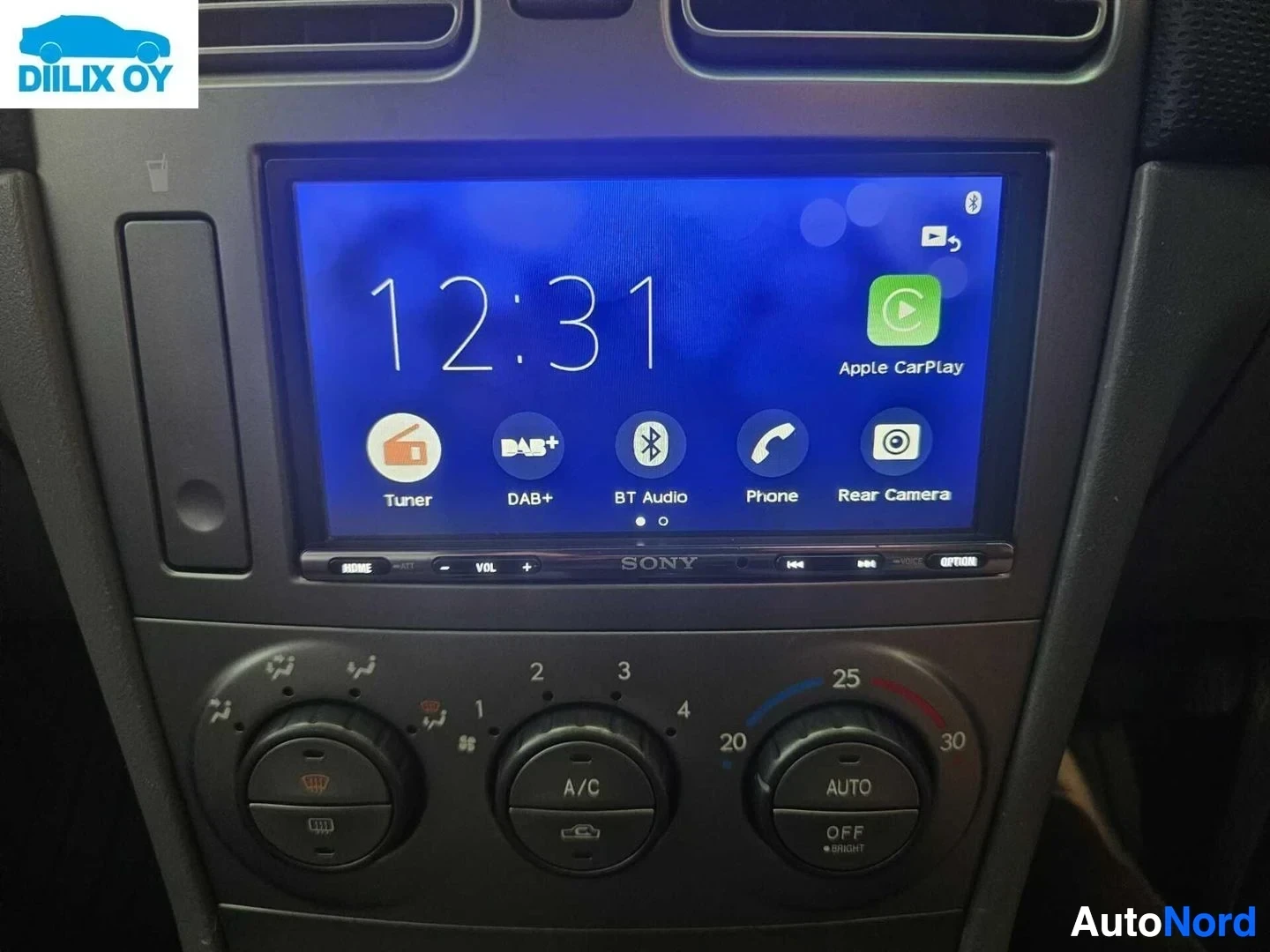 Yksityiskohta: Kosketusnäytön päävalikko, näkyy kello 12:31, Apple CarPlay, DAB+, Bluetooth Audio, Phone ja Rear Camera -kuvakkeet.
