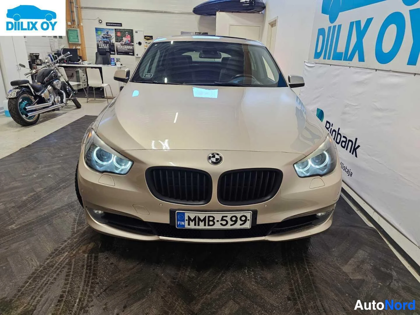 Edestä: Hopeanvärinen BMW Gran Turismo etunäkymässä, suoraan kohti kameraa. Kaksoissilmäinen LED-valaistus, musta säleikkö, rekisterikyltti näkyy. Taustalla hal