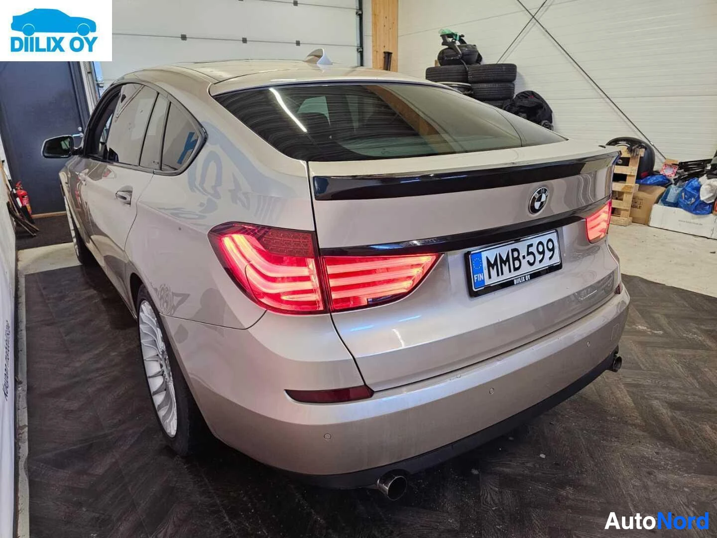 Takaviisto: BMW Gran Turismon takaosa kolmen neljänneksen kulmasta, auton nenä osoittaa oikealle. Näkyvissä LED-takavalot, rekisterikylpi ja harmaa väri