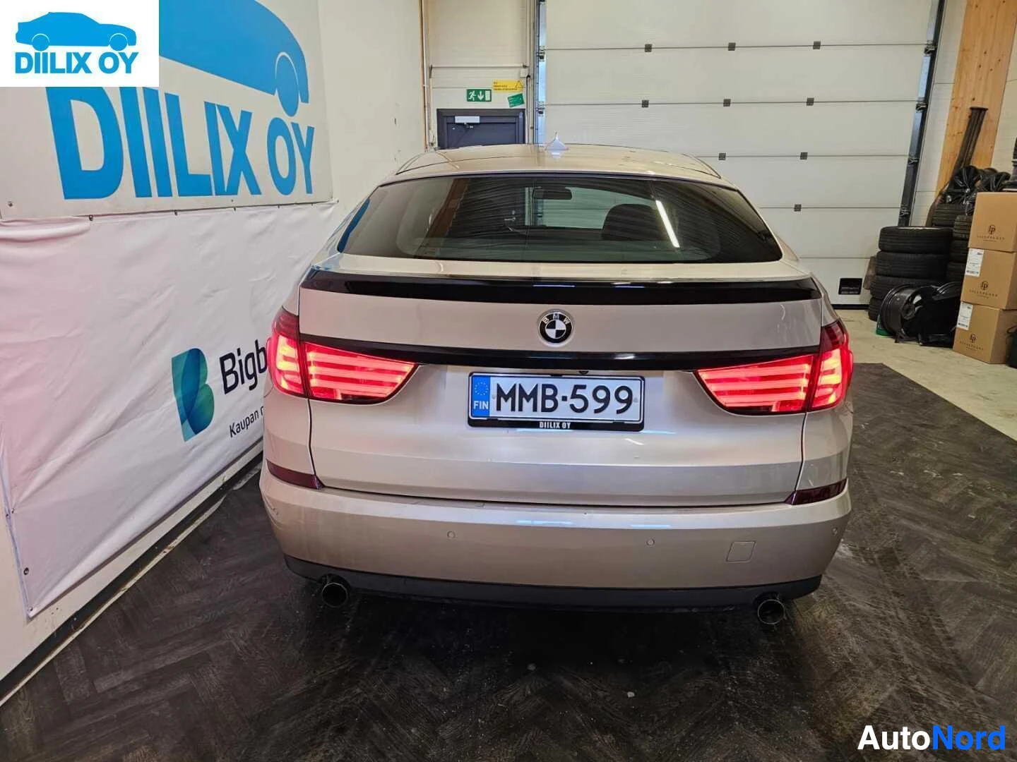 Takaa: Hopeanvärinen BMW 535 Gran Turismo, näkyy takaosa autotallissa, rekisterikyltti