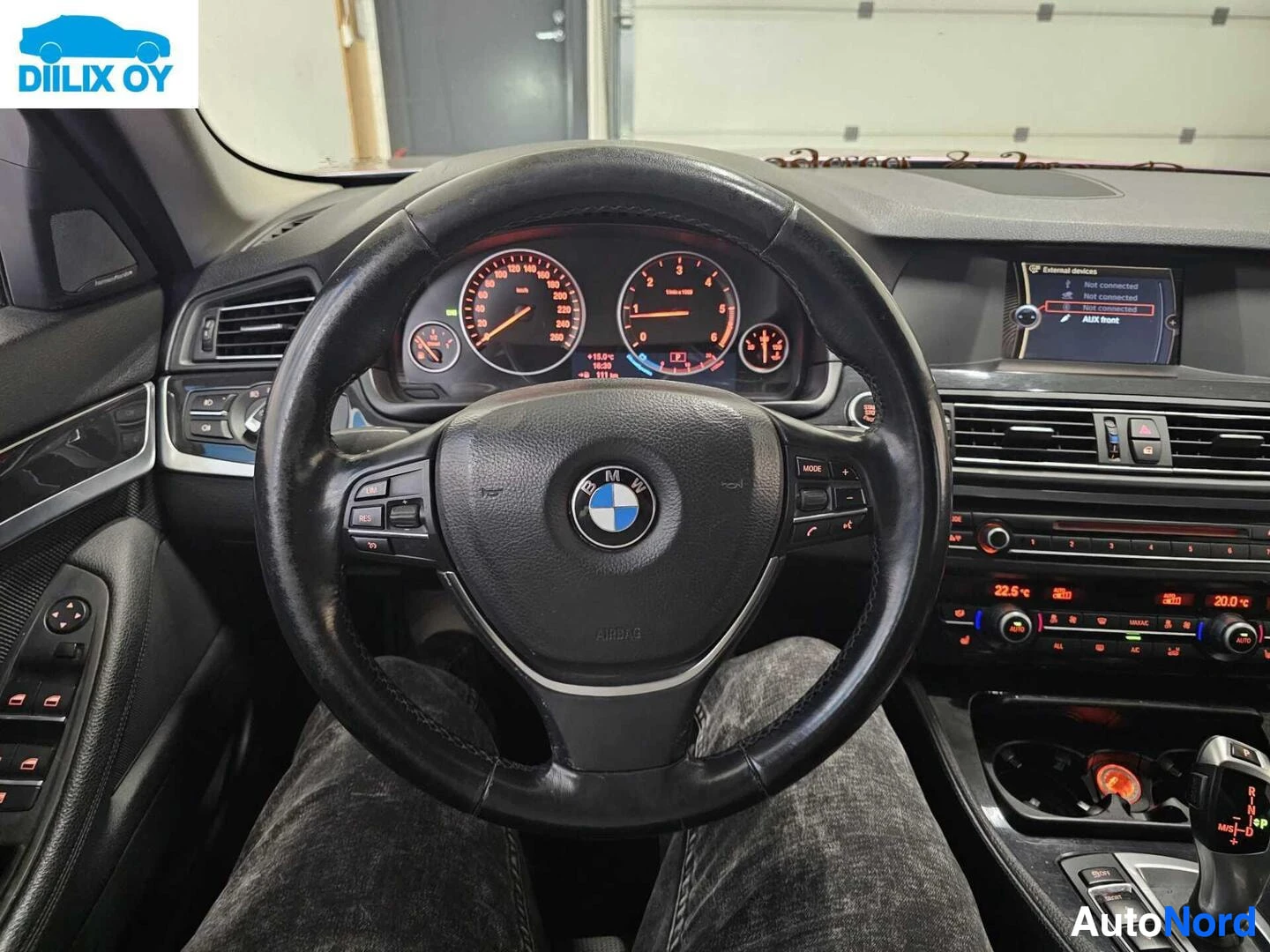 Ohjaamo: Naulakko, BMW-logo ohjauspyörässä, mittaristo ja ilmastoinnin säätöpaneelit näkyvät.