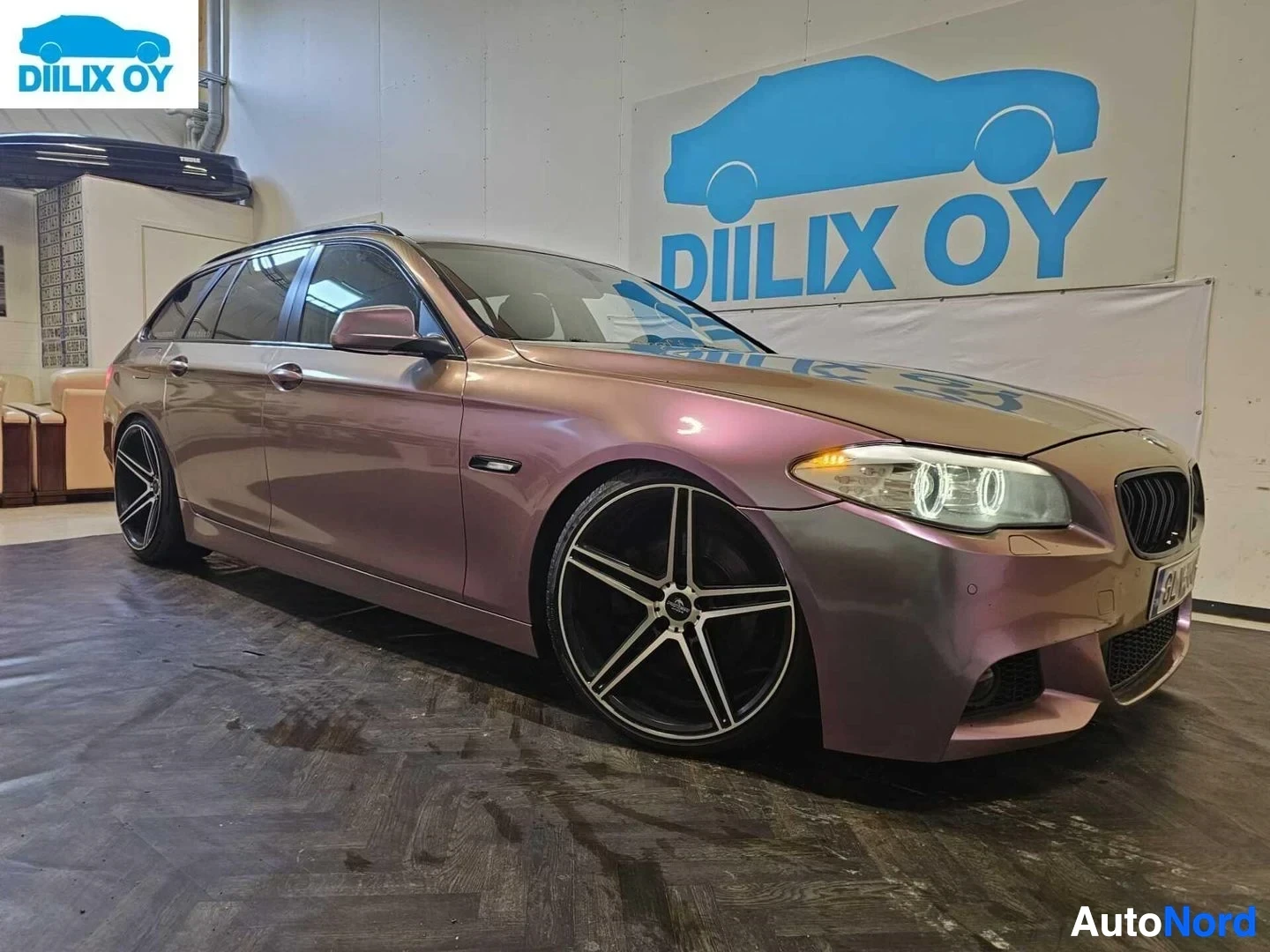 Etuviisto, nokka oikealle: Etukulma-näkymä BMW-farmista, violetti metallinkirjaus, LED-ajovalot näkyvillä, valkoiset vanteet ja musta säleikkö