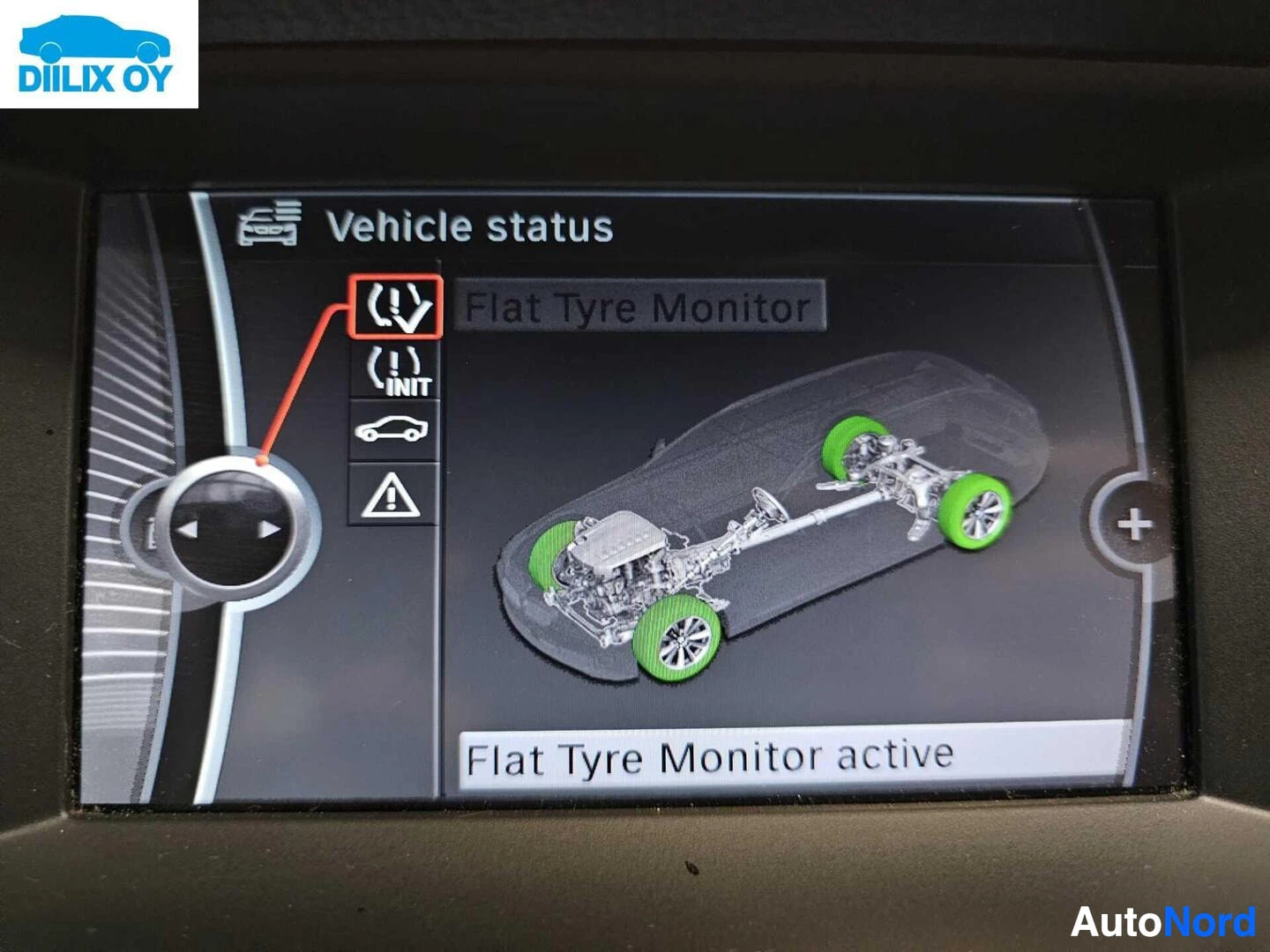 Yksityiskohta: Ajoneuvon infotainment-näytön näyttö "Vehicle status" -valikossa, jossa näkyy "Flat Tyre Monitor" ja "Flat Tyre Monitor active" -teksti sekä ajoneuvon alusta ja