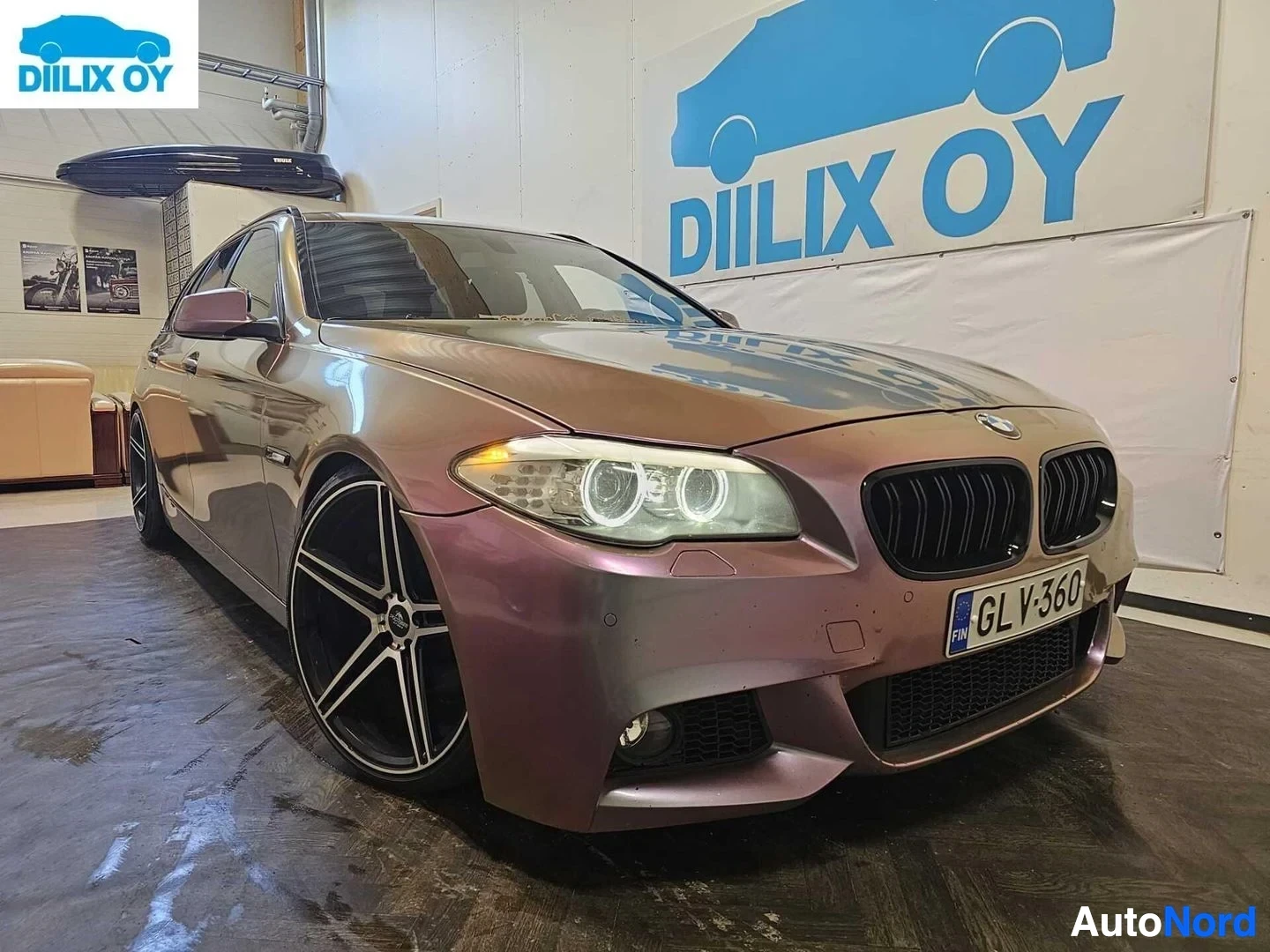 Etuviisto, nokka vasemmalle: Etupuoli läheltä kuvatusta BMW-farmista violetilla metallinkirjauksella, valkoisten vanteiden ja LED-ajovalojen näkyvillä
