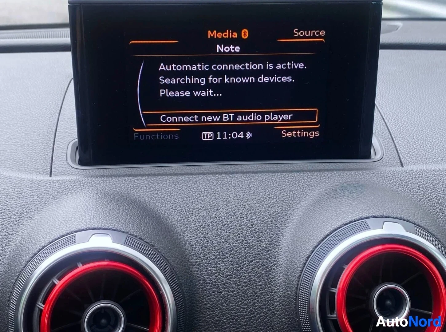 Ohjaamo: Näyttö näyttää Bluetooth-kytkennän tilaa. Teksti 'Media ø', 'Source', 'Automatic connection is active. Searching for known devices. Please wait...' ja 'Connect