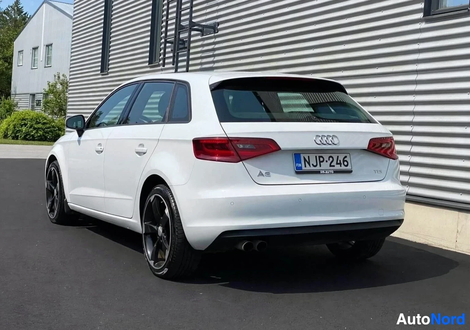 Takaviisto: Valkoinen Audi-auto takaa kolmelta neljäsosalta kuvattuna, näkyvissä takaosio ja sivupuoli