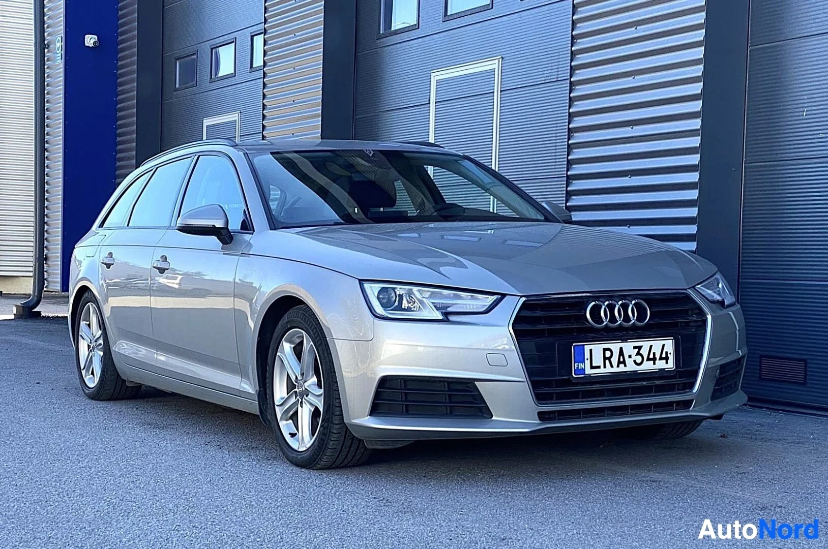 Etuviisto, nokka oikealle: Hopeanvärinen Audi A4 Avant edestä oikealta kuvattuna, rekisternumero näkyvissä
