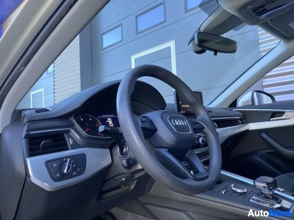 Etuistuimet: Ohjauspyörä ja instrumenttipaneeli lähikuvassa; näkyy Audi-logo, nopeusmittari, kierrosluku ja vasemmalla puolella valon säätimen painike.