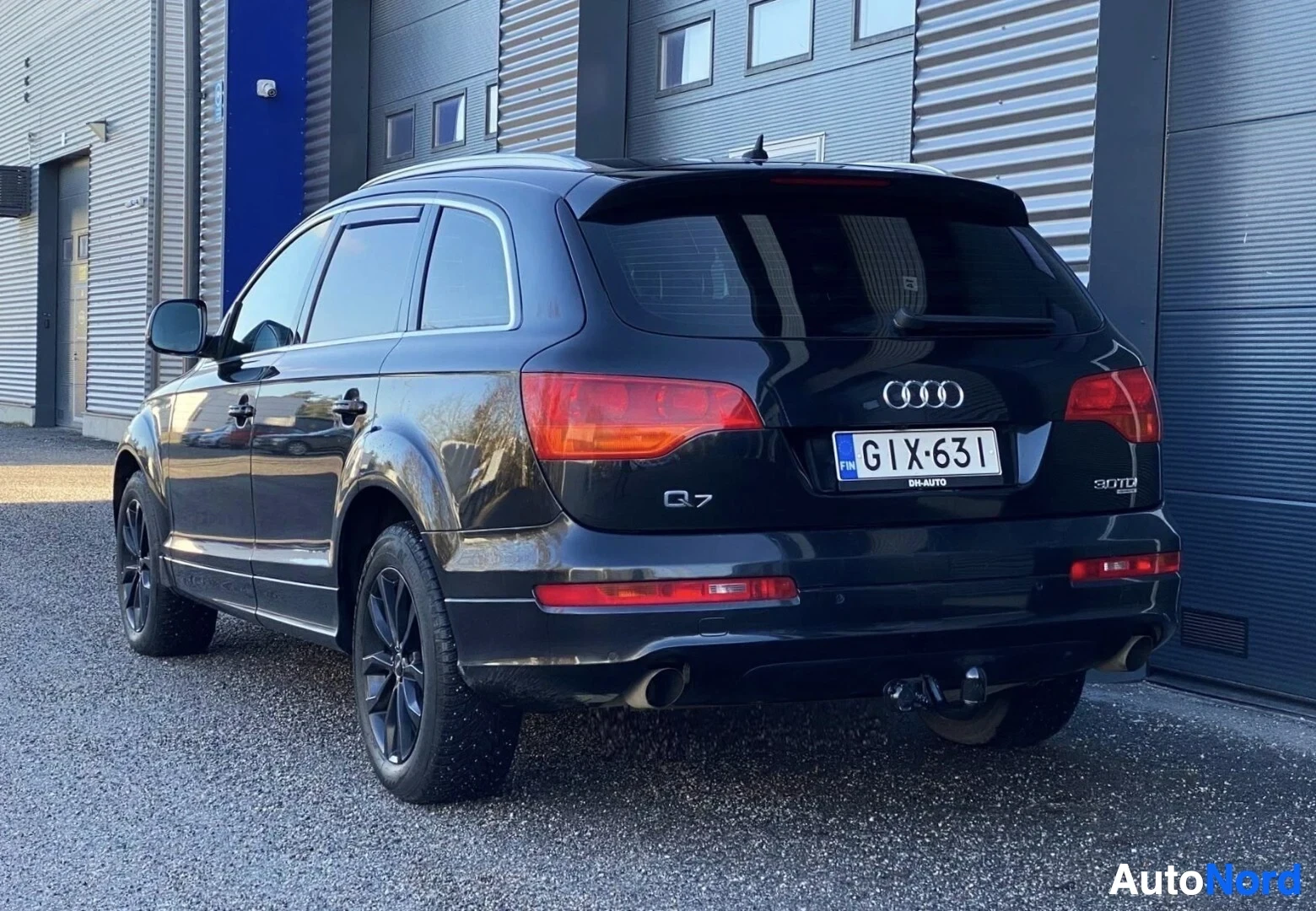 Takaviisto: Musta Audi Q7 takavasemmalta kuvattuna, rekisterikilpi ja takavalot näkyvillä