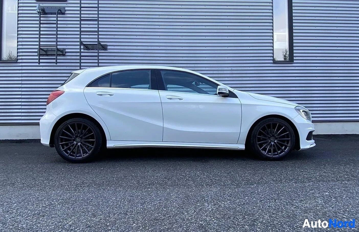 Sivulta: Valkoinen Mercedes-Benz A-sarja viistoperä, näkymä sivusta vasemmalta, parkissa.