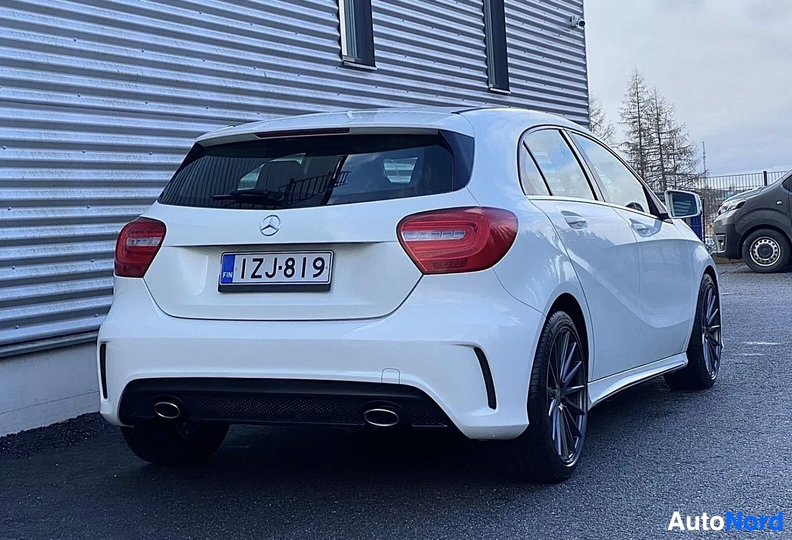 Takaa: Valkoinen Mercedes-Benz pienoisauto takaosasta. Punaisia takavaloposteria ja kaksoisputkista pakoputkea näkyy. Rekisterikyltti näkyy