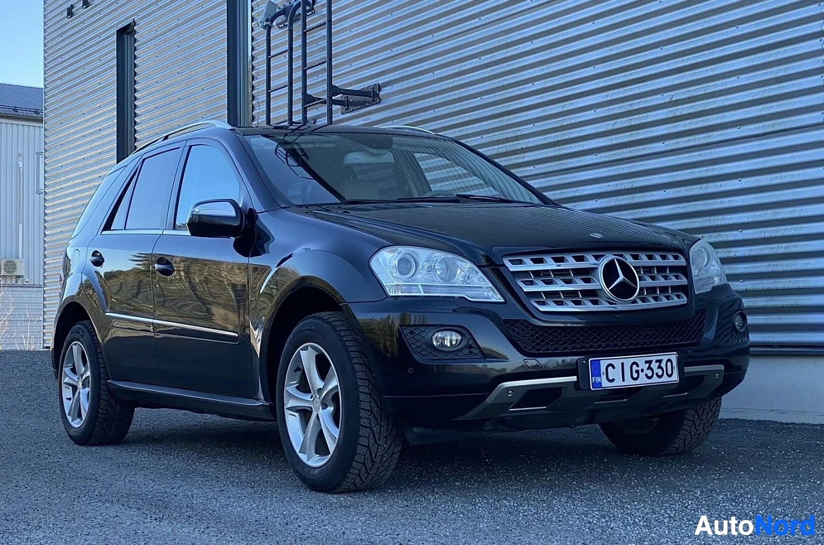 Etuviisto, nokka oikealle: Musta Mercedes-Benz ML -mallinen maastoauto, etupuoli oikealle katsottaessa, rekisterikilvessä CIG330