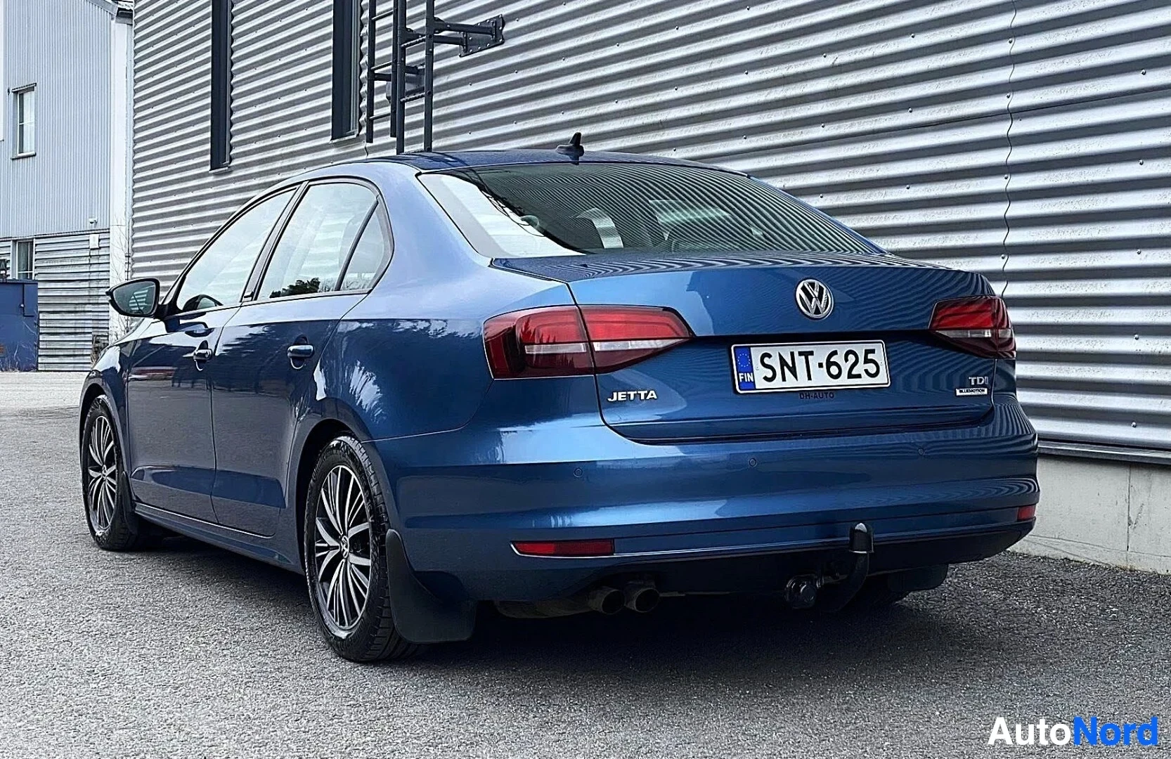 Takaa: Sininen Volkswagen Jetta sedan takaa oikealta puolelta, rekisterinumero näkyvissä, 'JETTA' ja 'TDI' -merkinnät takaosassa