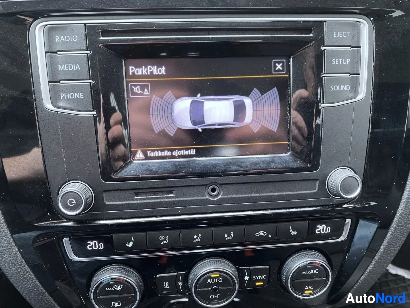 Yksityiskohta: Auton infotainment-näyttö näyttää ParkPilot-pysäköintitunnistusjärjestelmää näkökulman yläpuolella.