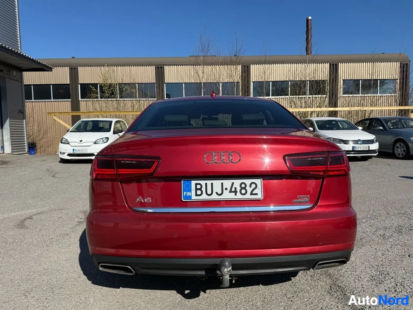 Takaa: Punainen Audi A6 sedan näkyy takaa, rekisterilevy näkyvissä, tow bar asennettu