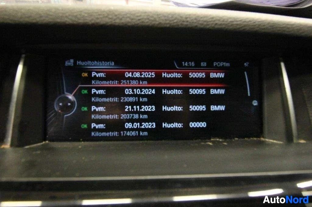 Yksityiskohta: Ajoneuvon infotainment-näytön huoltohistoria-näyttö, jossa näkyy useita huoltokirjauksia päivämäärillä, ajokilometreillä ja BMW-merkinnällä