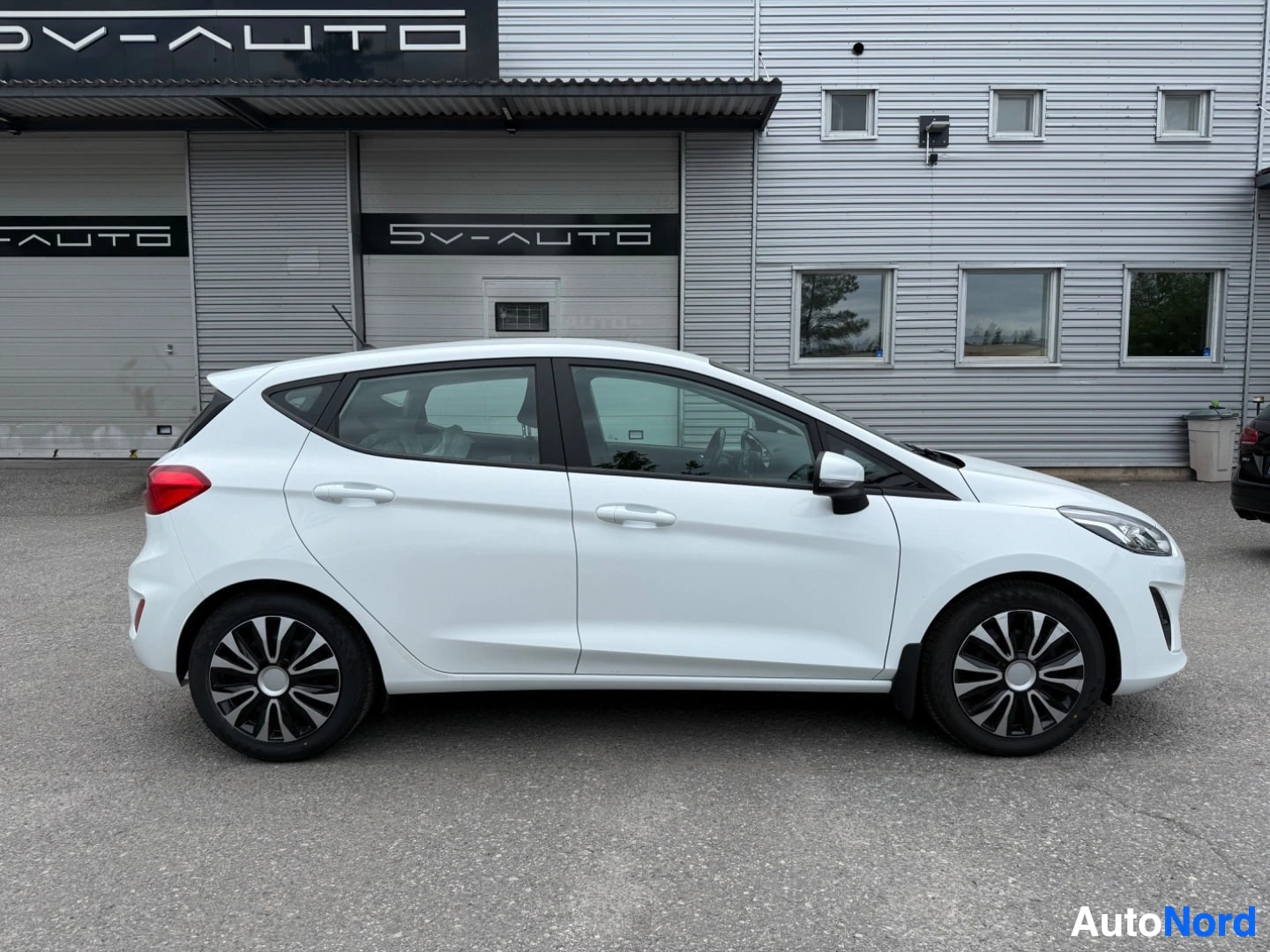 Sivulta: Valkoinen Ford Fiesta sivukuva oikealta puolelta näkymä pysäköintialueella.