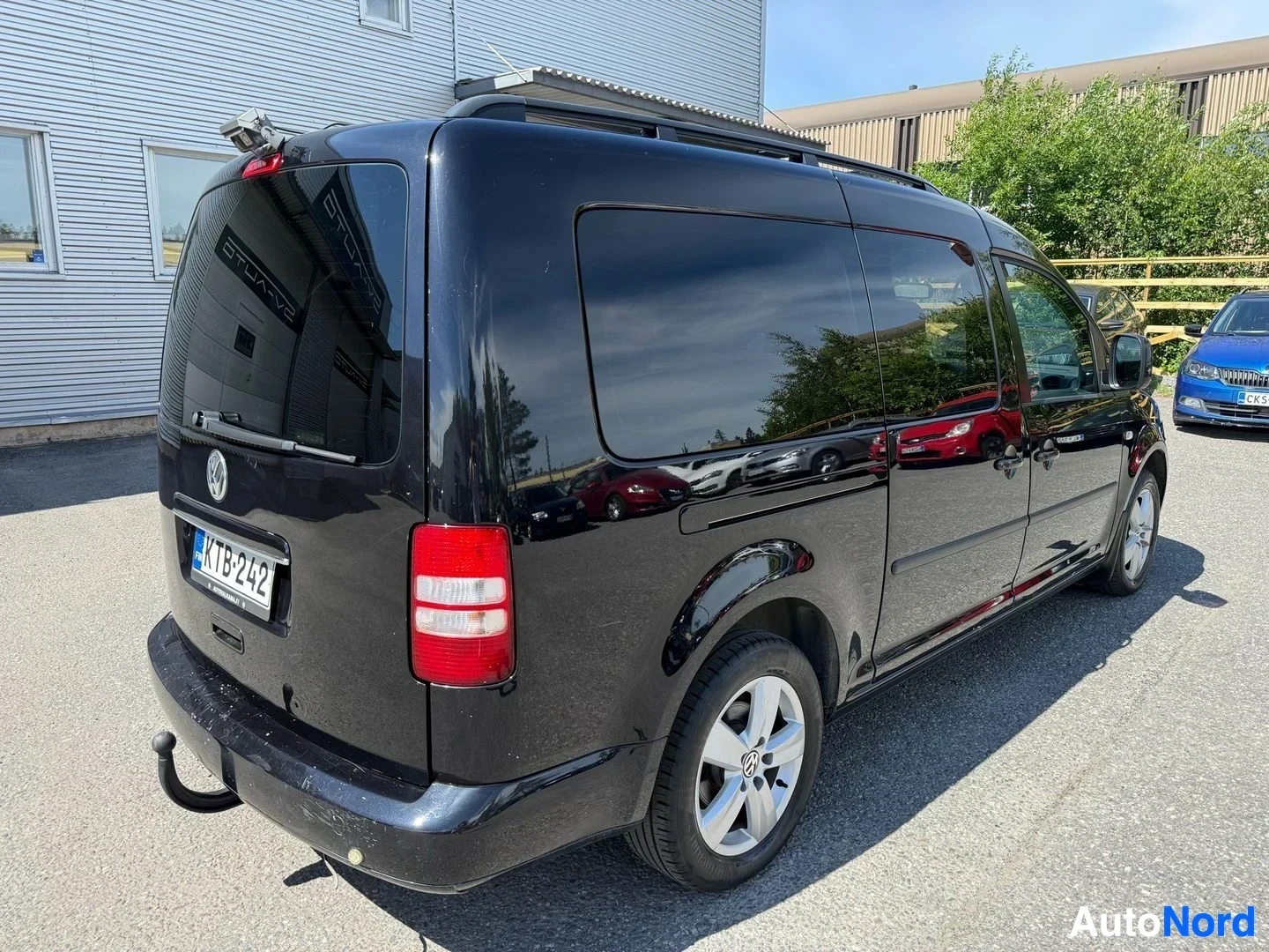 Takaviisto: Musta Volkswagen Caddy -pakettiauto takaosasta kuvattuna, näkyy vetokoukku ja taka-akselit