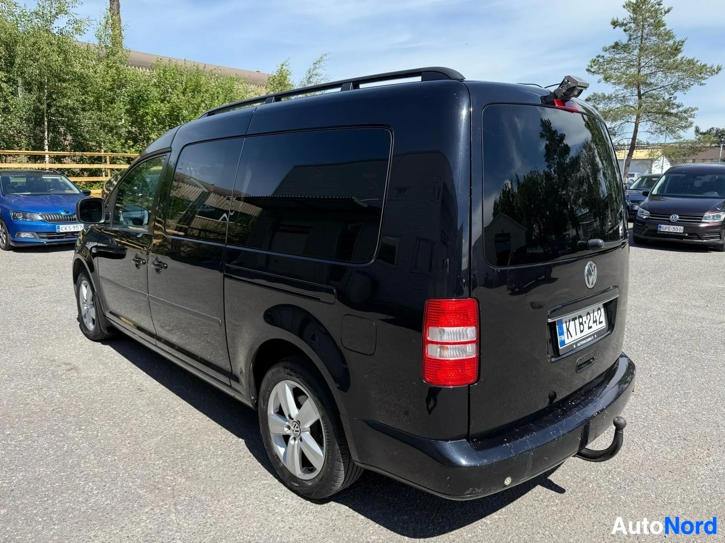 Takaviisto: Musta Volkswagen-pakettiauton oikea sivu kolmen neljänneksen näkymässä, näkyy ovi ja lokasuoja
