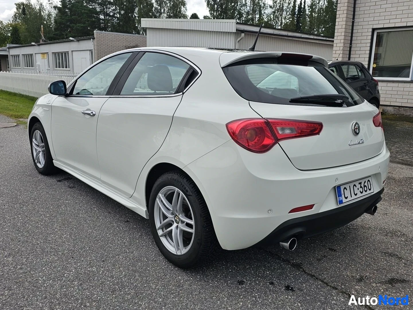 Takaviisto: Valkoinen Alfa Romeo Giulietta, takanäkymä oikealta kulmasta, avoin ovi, rekisterinumero