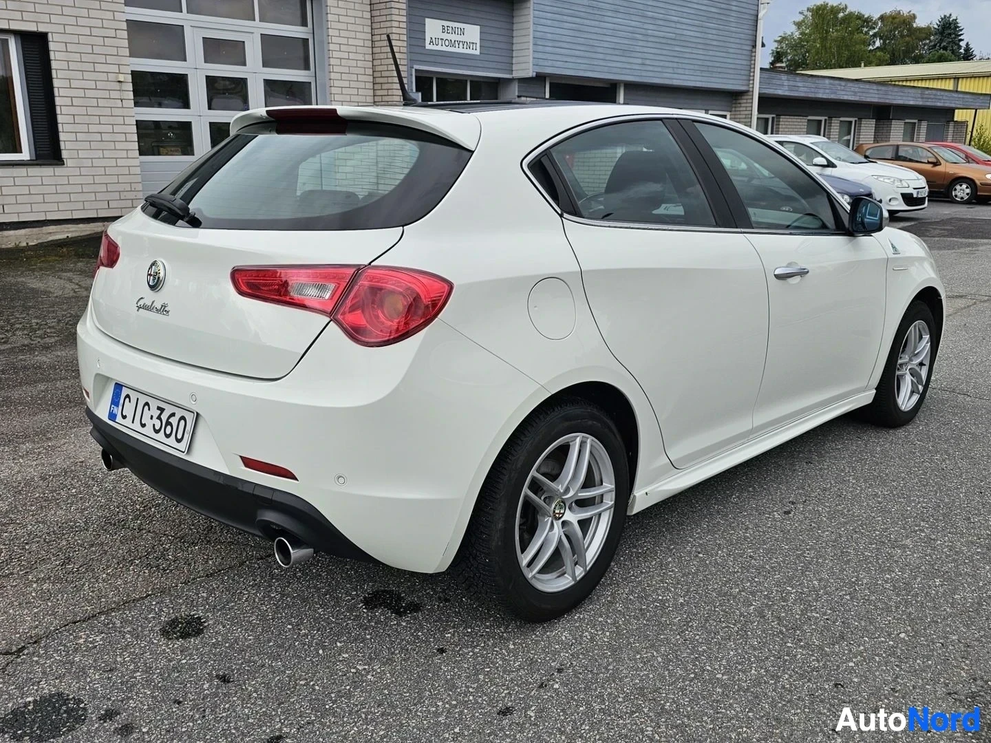 Takaviisto: Valkoinen Alfa Romeo Giulietta, takanäkymä oikealta kulmasta, avoin ovi, rekisterinumero