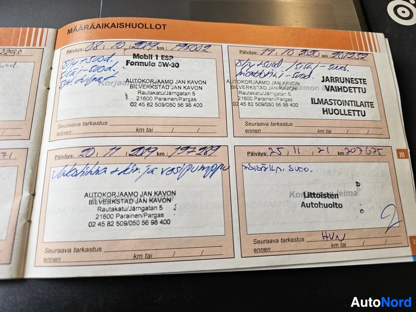 Asiakirja: Suomalainen määräaikaishuollon kirja, jossa useiden autokorjaamon toimipisteiden palveluksia dokumentoitu käsintkirjoitetuin merkinnöin sisältäen päivämäärät, a