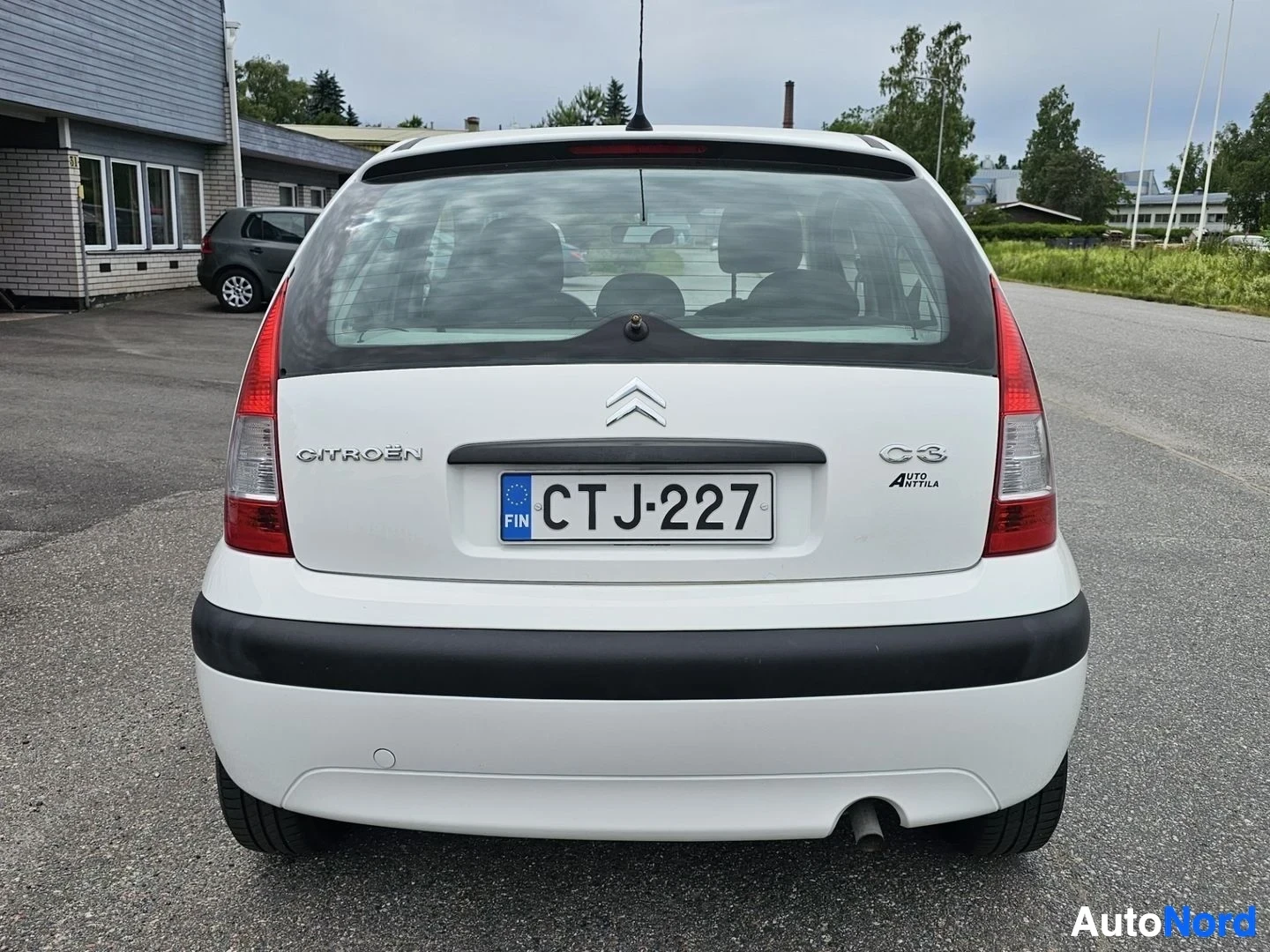 Takaa: Valkoinen Citroën C3, takaa näkymä, pysäköitynä asfalttialueelle