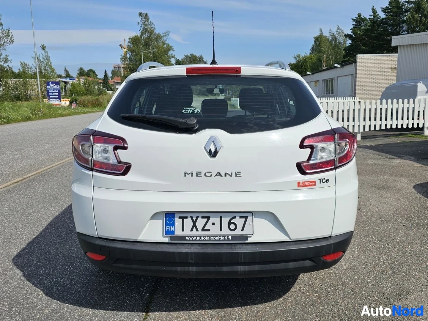 Takaa: Valkoinen Renault Megane farmari, takaa, parkkipaikalla, taksiraidat näkyvissä, TC9-merkki näkyy takaosassa