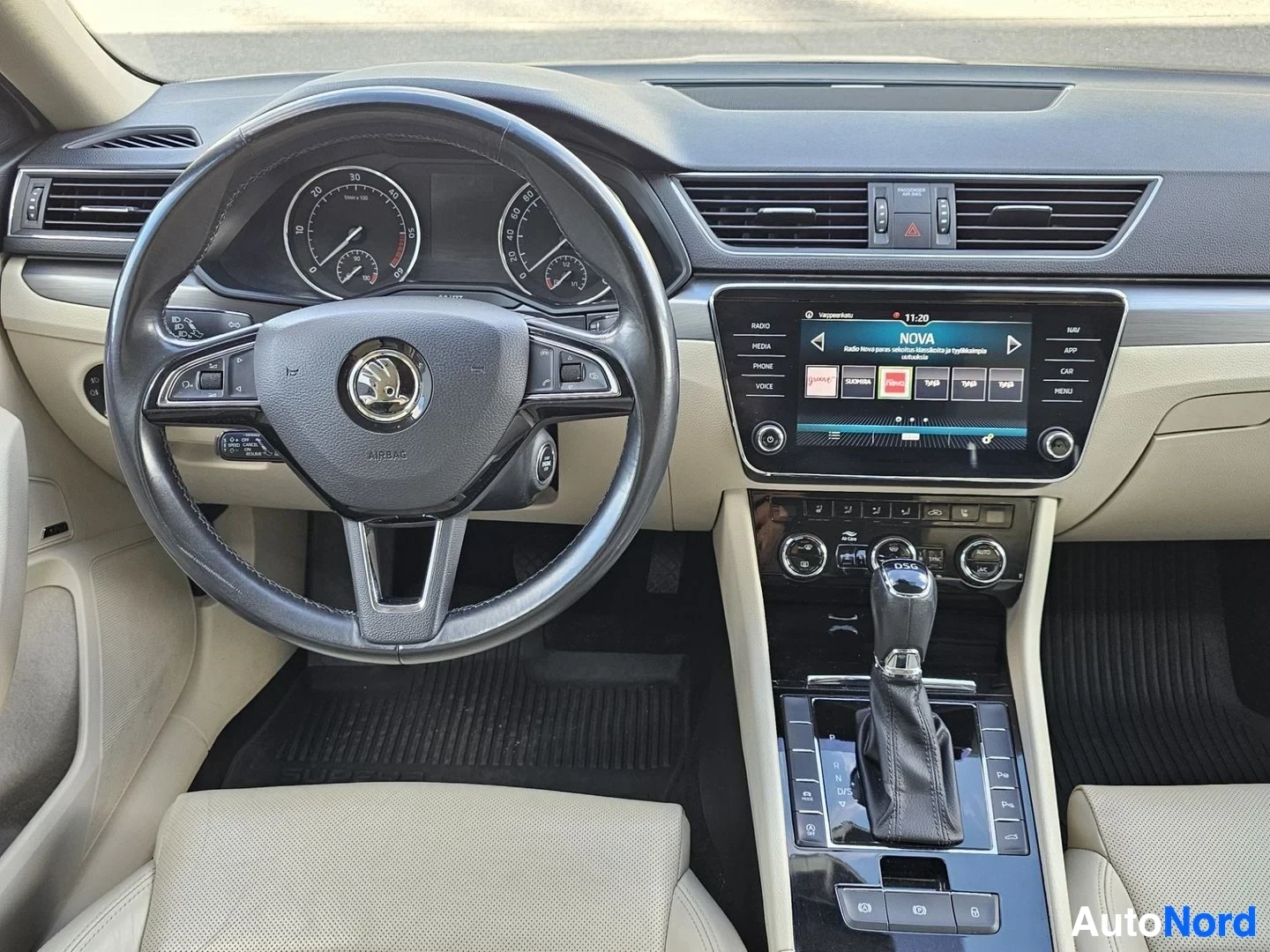 Ohjaamo: Lähikaupunki ohjauspyörän ja keskikonsolin yksityiskohdista: kaksoismittaristo, Skoda-logo, infotainment-järjestelmä ja vaihteistovipu