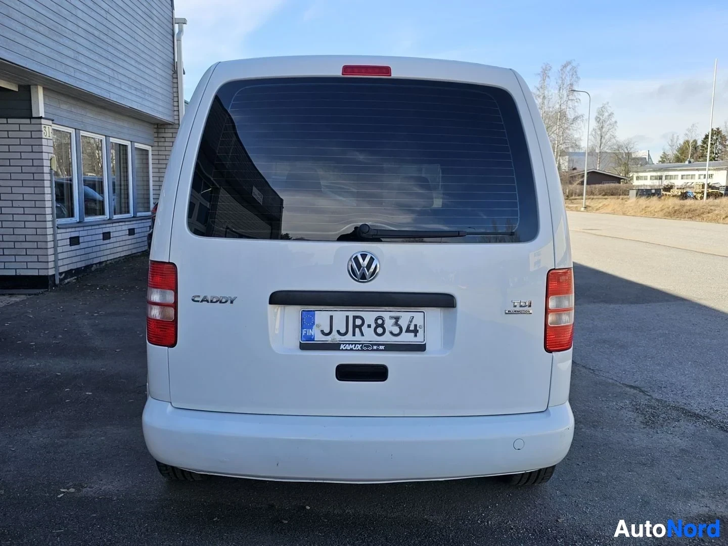 Takaa: Valkoinen Volkswagen Caddy näyttää suoraan takaa, rekisterikilvessä, takaoven yllä teksti 'CADDY' ja 'TDI'