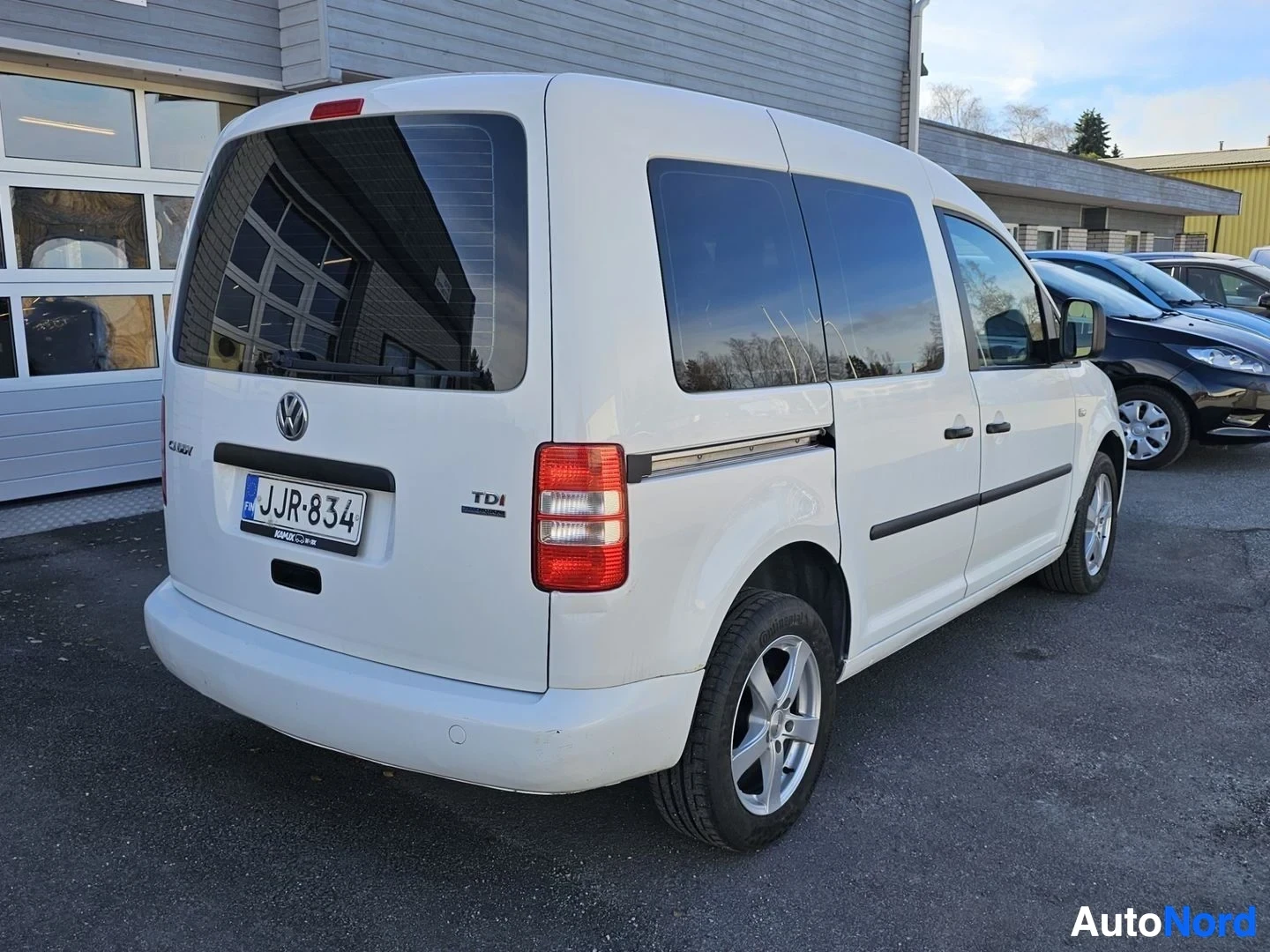 Takaviisto: Valkoinen Volkswagen Caddy näyttää takaa ja oikealta puolelta, rekisterikilvessä, takaoven yllä teksti 'TDI'