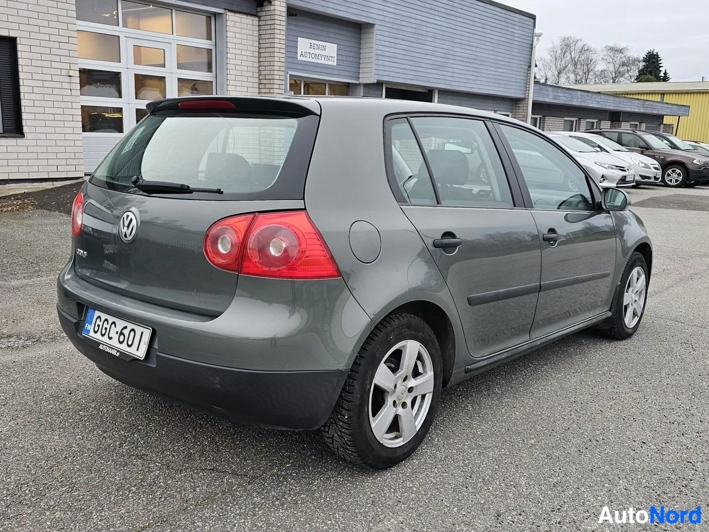 Takaviisto: Harmaa Volkswagen Golf viistoperä, takapuoli vasemmalta kuvattuna. Ovi auki, näkyvissä takaovi ja takapyörä. Rekisterikilpi