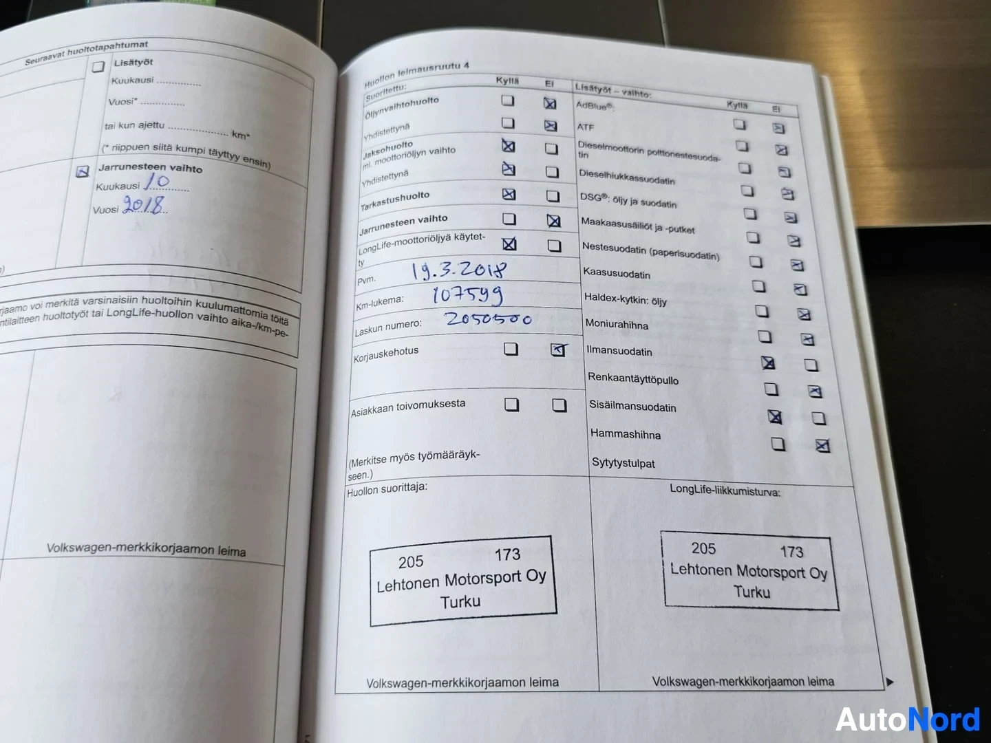 Asiakirja: Volkswagen-merkkikorjaamon huoltopalvelu kirja, avoinna sivuilla joissa näkyy huoltohistoria, käsinkirjoitettuja merkintöjä, päivämäärä 19.3.2019, kilometriluke