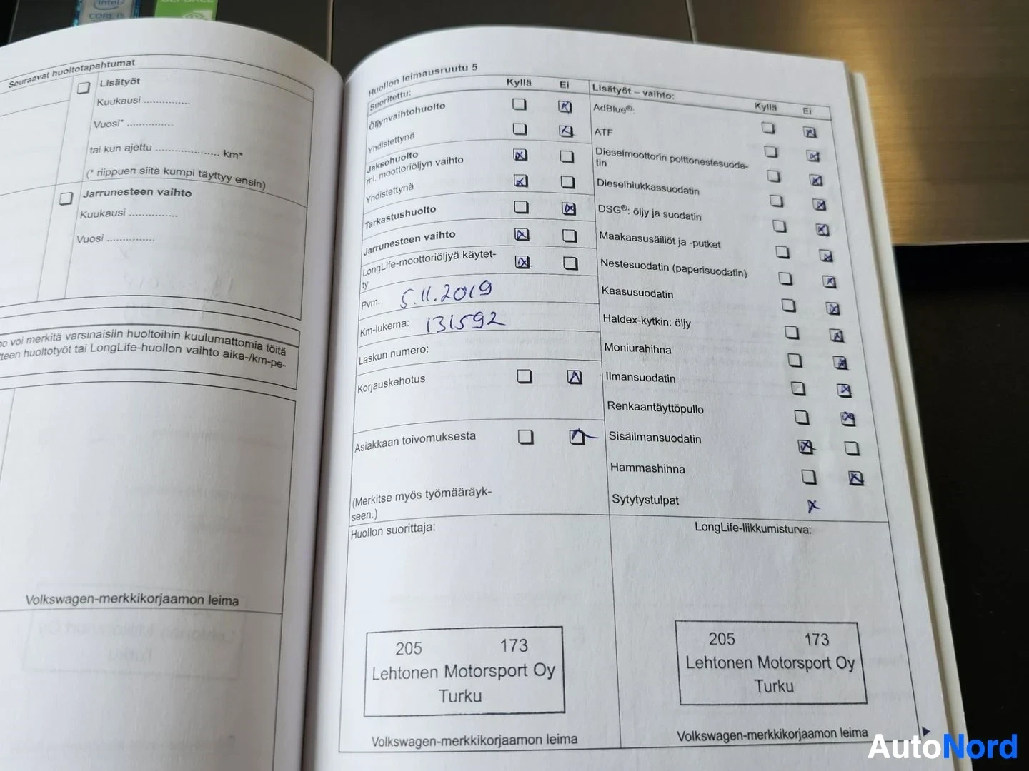 Asiakirja: Volkswagen-merkkikorjaamon huoltopalvelu kirja, avoinna sivuilla joissa näkyy huoltohistoria, käsinkirjoitettuja merkintöjä, päivämäärä 5.11.2019, kilometriluke