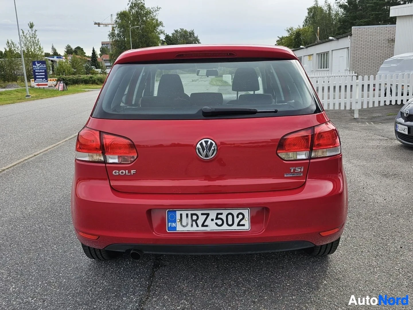 Takaa: Punaisen Volkswagen Golf -hatchbackin takaosa suoraan, jossa näkyy rekisterinumero. Teksti 'GOLF' ja 'TSI' näkyvät takaosassa sekä kaksi puna-valkoista