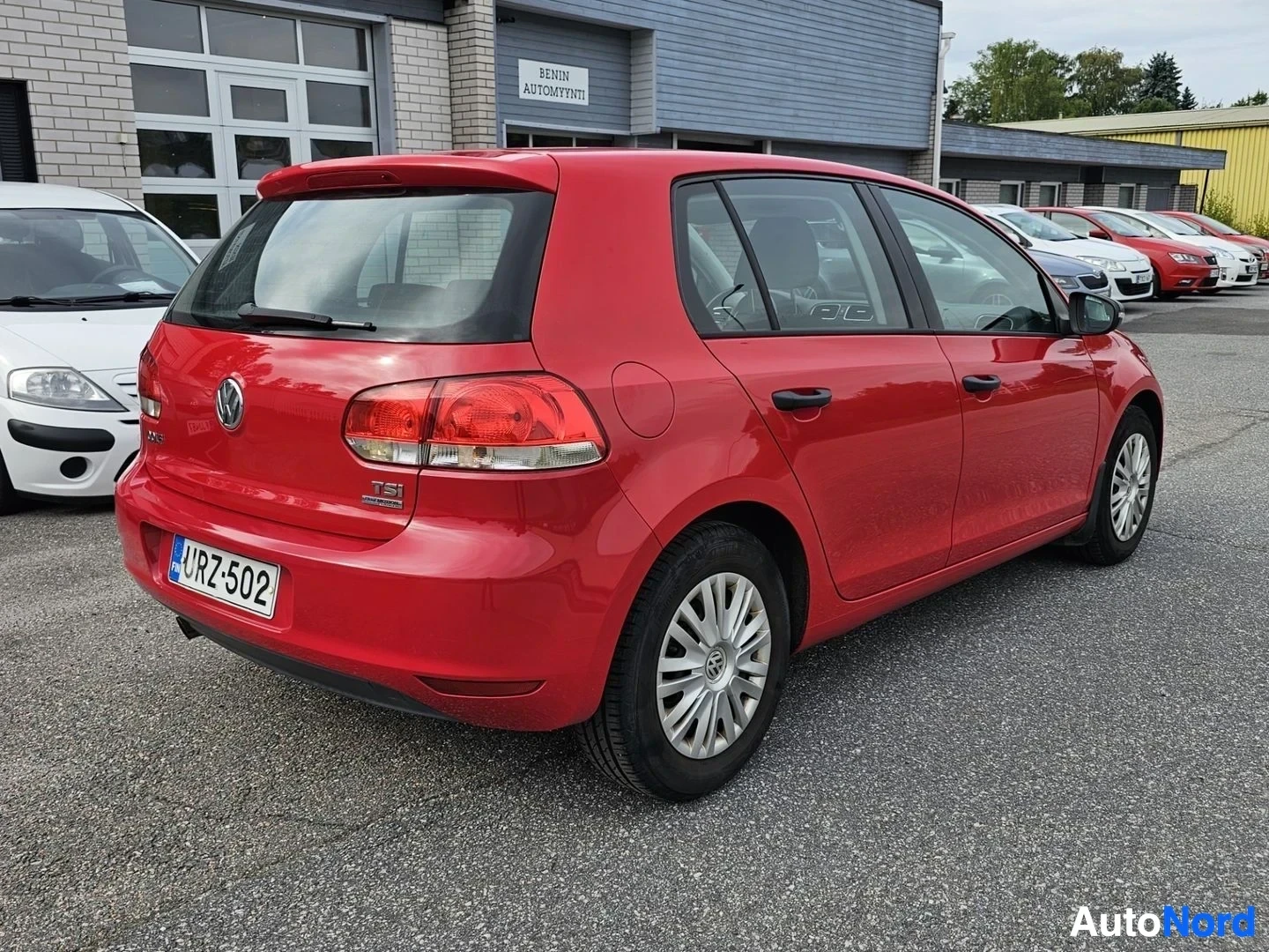 Takaviisto: Punainen Volkswagen Golf -hatchback takaa-viistosta oikealle, jossa näkyy takaosa ja oikea sivu. Rekisterinumero näkyy sivulla. Teksti '1.2 TSI' näkyy t
