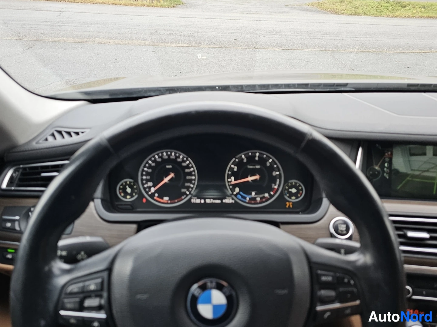 Ohjaamo: Auton sisätila ohjaamosta katsottuna, näkyvillä kolme mittaria keskellä ohjauspyörän takana, BMW-logo ohjauspyörän keskellä, osittain näkyvissä oikealla puolell