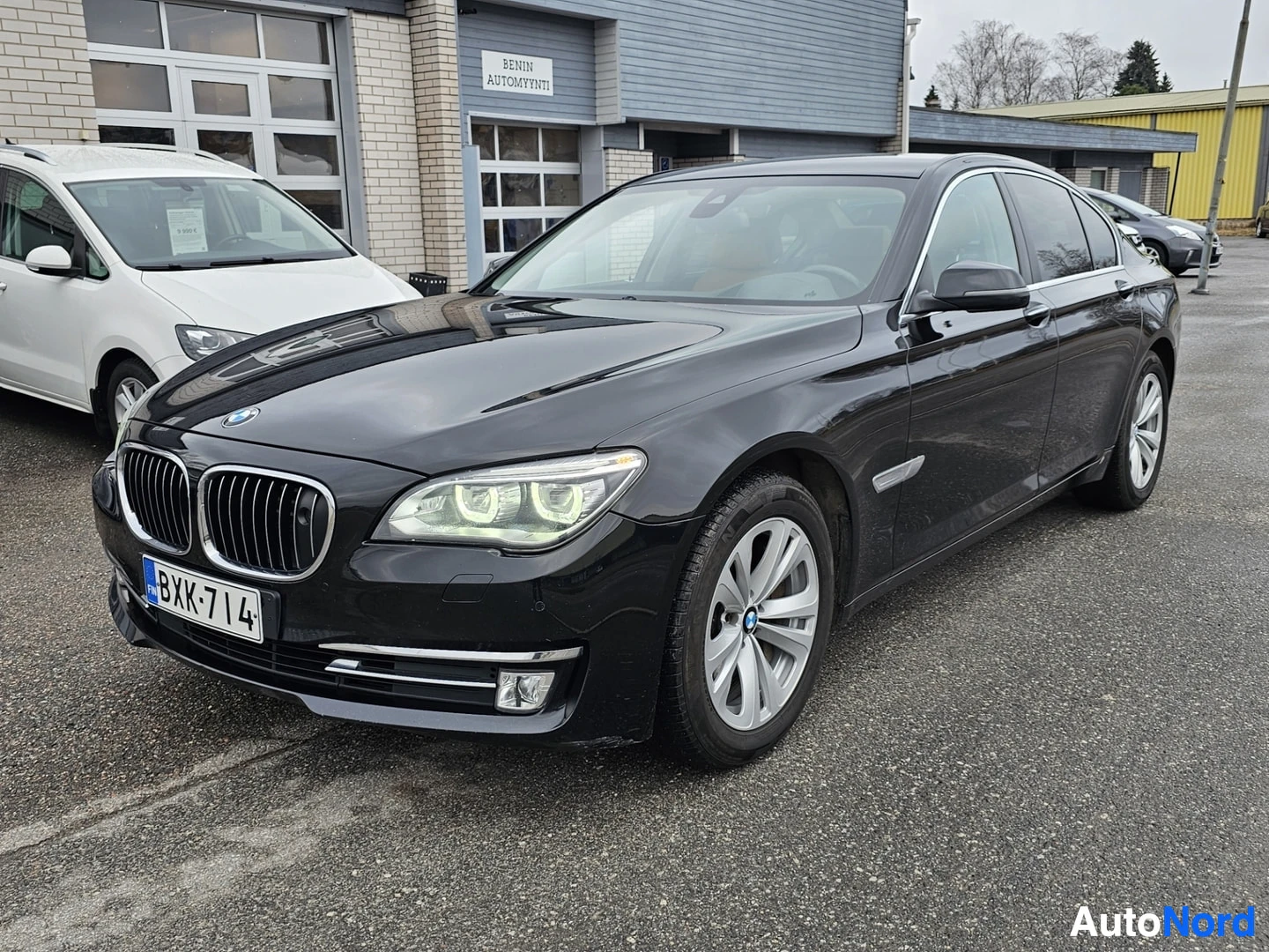 Etuviisto, nokka vasemmalle: Musta BMW-luksussedan kuvatussa kolmiulotteisesti vasemmalta edestä, näkyy kokonainen etupuoli ja vasen sivu. Tummanväriset säteilevät etugrillissä, LE