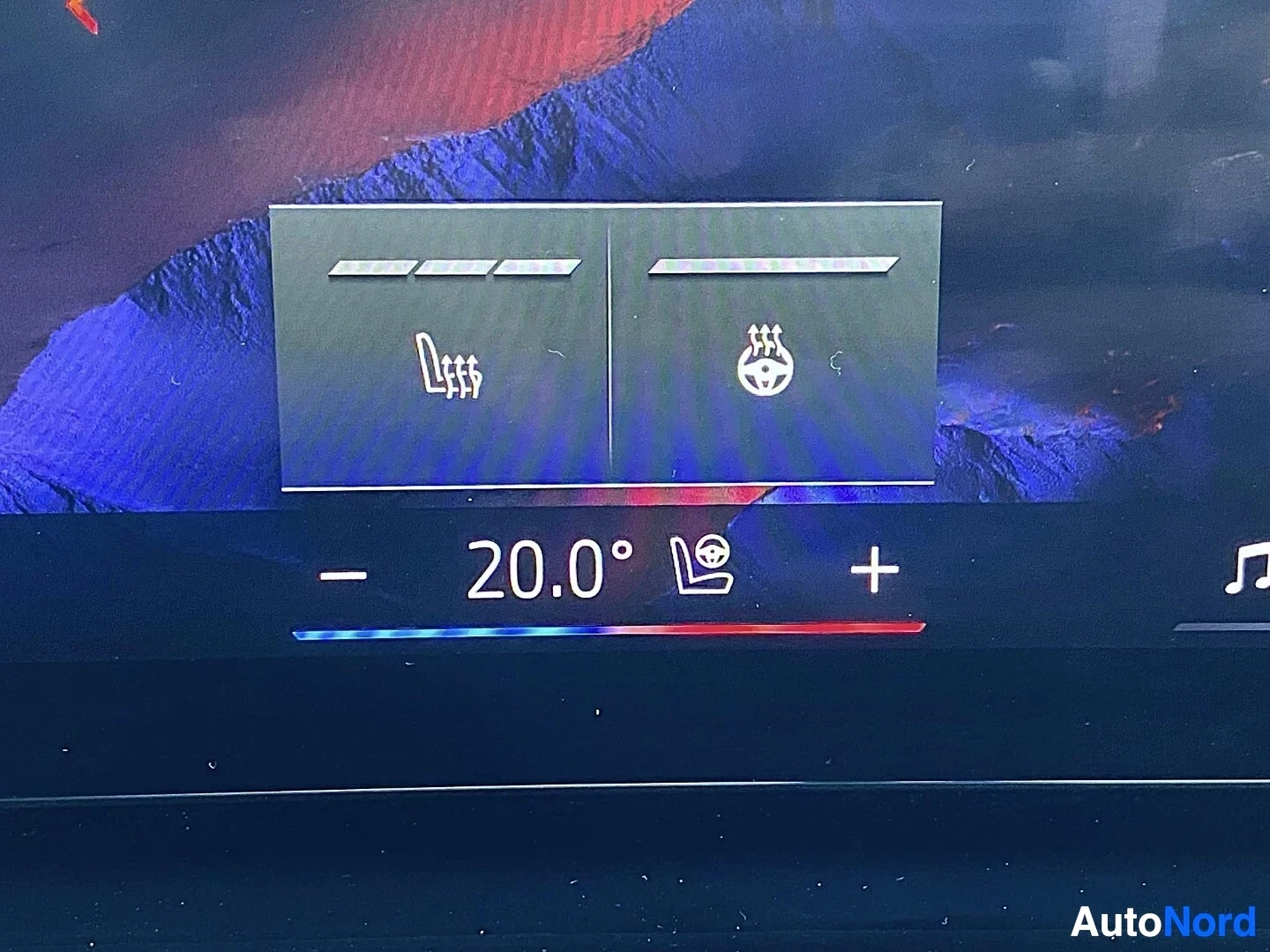 Yksityiskohta: Auton infotainment-näytön valikko jossa kaksi painiketta: vasemmalla 'Lass' -symboli, oikealla tasasähköä esittävä symboli, alla lämpötilakaavio 20,0 astetta