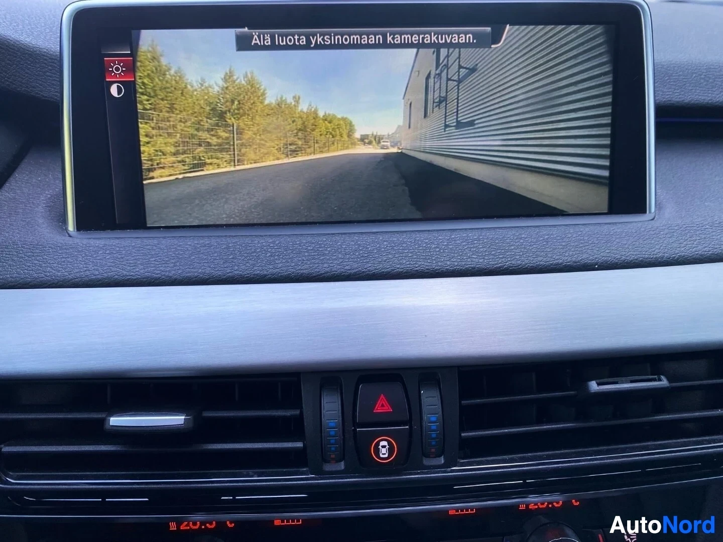 Ohjaamo: Auton infotainment-näyttö näyttää peruutuskameran kuvaa yhdessä hallintapaneelin kanssa.