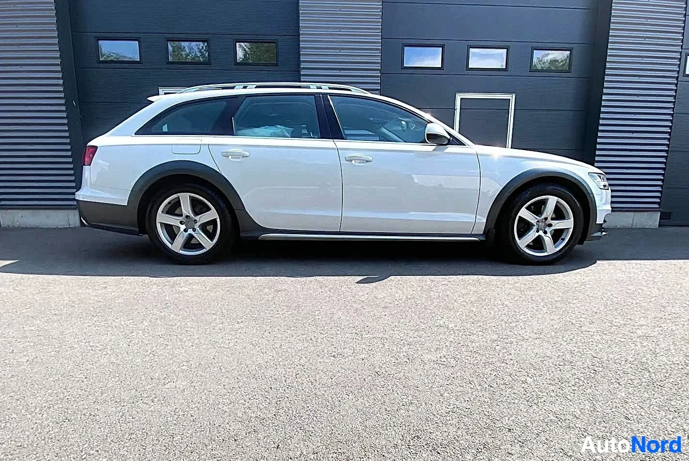 Sivulta: Audi farmari valkoinen sivukuva vasemmalta, neljä ovea näkyvissä, metallisen väriset vanteet