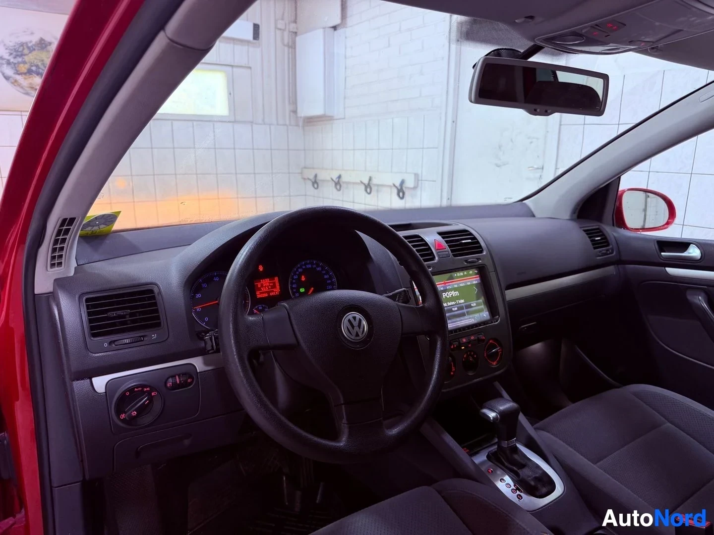 Ohjaamo: Volkswagen Golf -auton kojelauta ja ohjauspyörä edestä katsottuna, näkyvissä mittaristo ja keskikonsoli näytöllä
