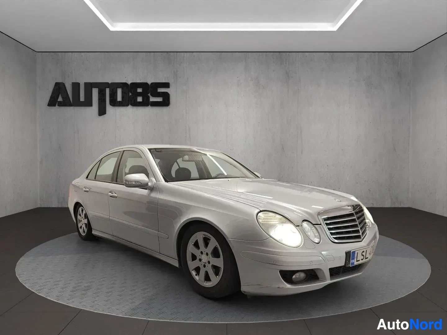 Sivulta: Hopea Mercedes-Benz E-sarjan sedan vasemmalla sivulla neljän oven sedan-kuvioinnissa studio-ympäristössä.