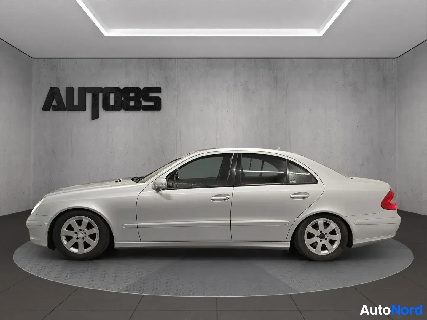 Sivulta: Valkoinen Mercedes-Benz -sarja, sivu, sisätiloissa betoniharjalla olevalla alustalla