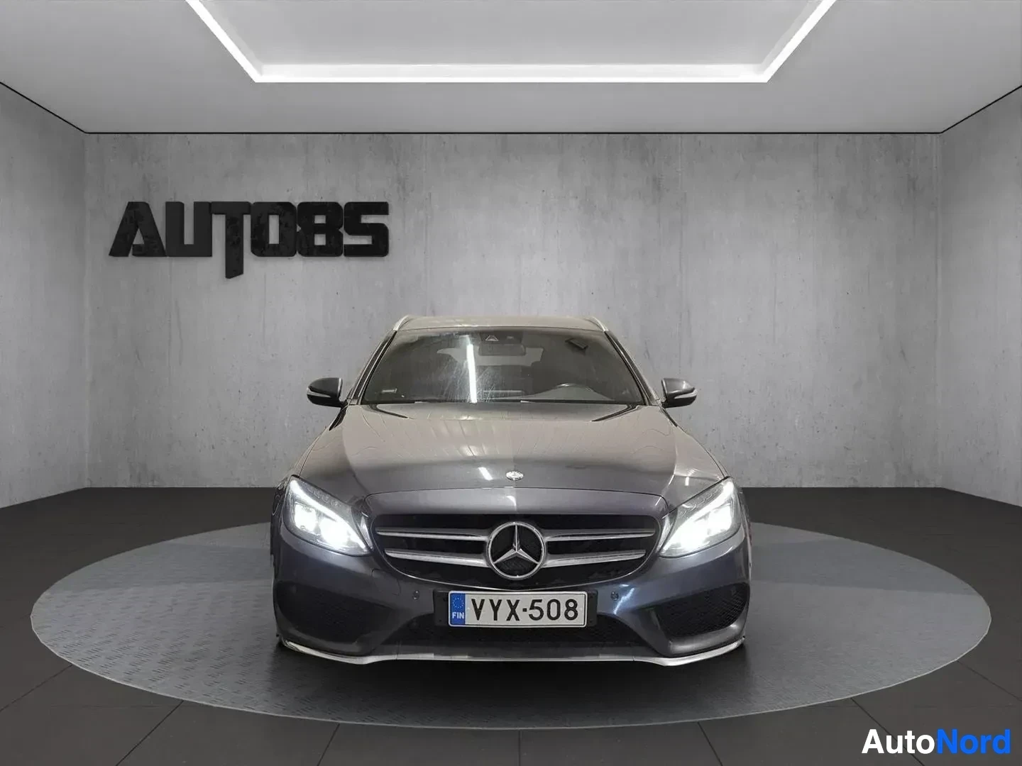 Edestä: Mercedes-Benz sedan, harmaa väri, etunäkymä, valkoisen katon showroomissa