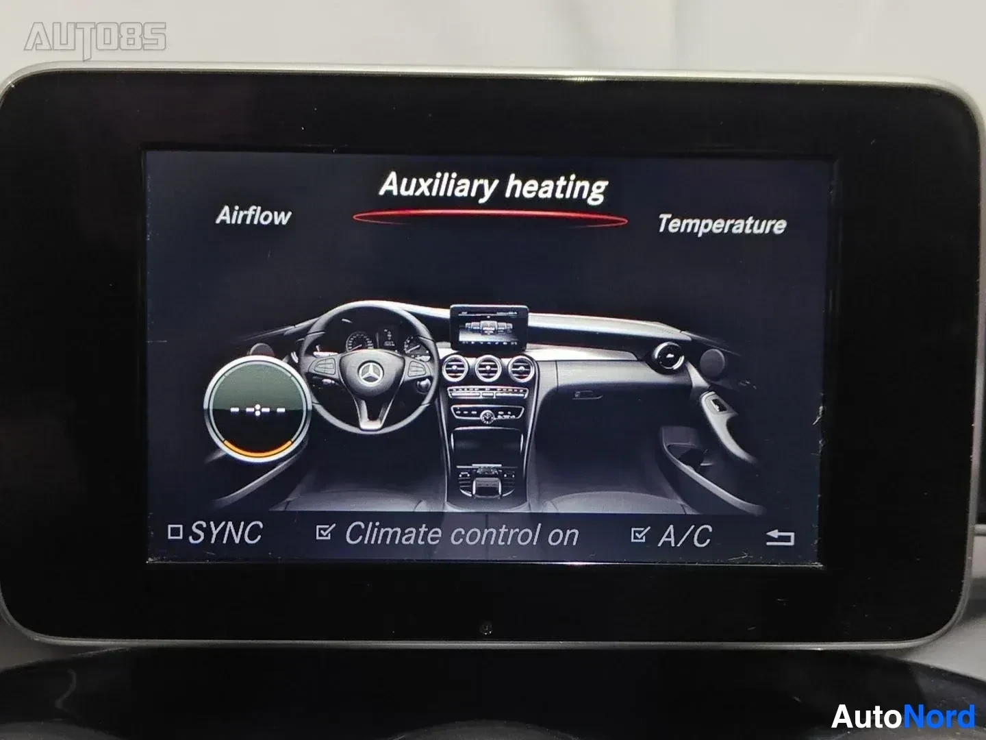 Yksityiskohta: Auton multimedia-näyttö näyttää apulämmityksen ohjausta. Näytöllä lukee "Auxiliary heating", "Airflow", "Temperature" ja painikkeet "SYNC", "Climate control on"