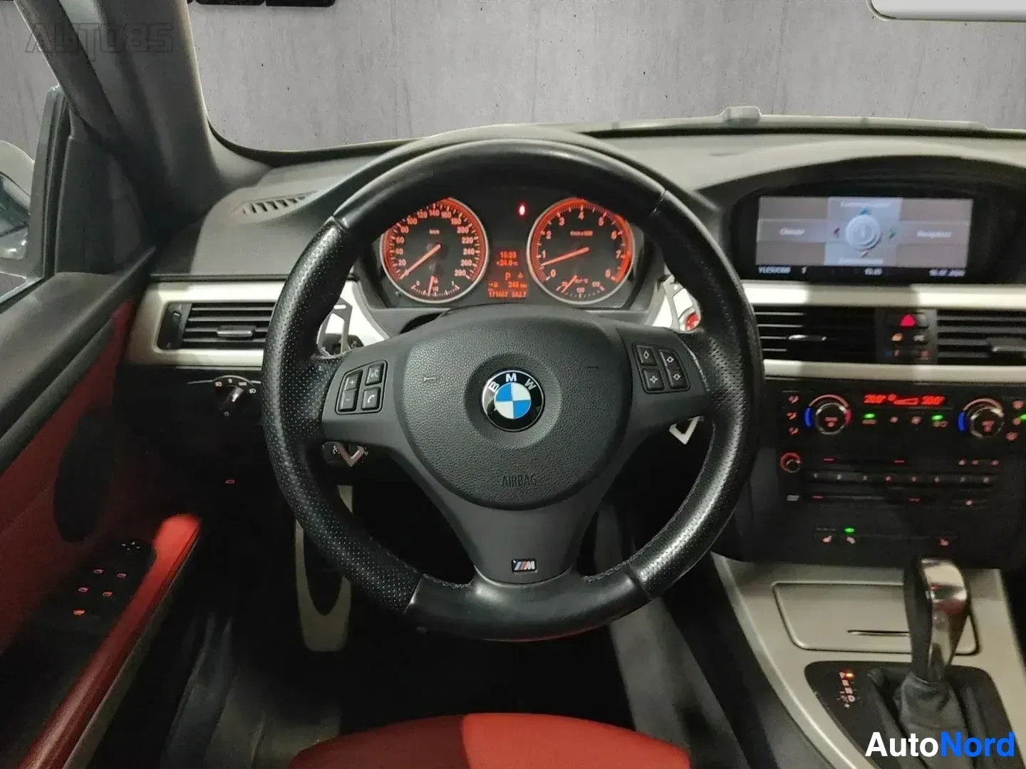 Ohjaamo: BMW:n ohjauspyörä ja kojelauta etunäkymässä, punainen instrumenttinäyttö ja harmaa sisustus